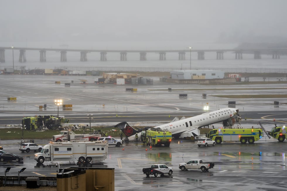 An Air Canada jet and Port Authority fire truck sit on the runway at LaGuardia Airport,...