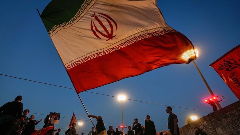 A man waves an Iranian flag during funeral ceremonies for slain Iranian Supreme Leader...