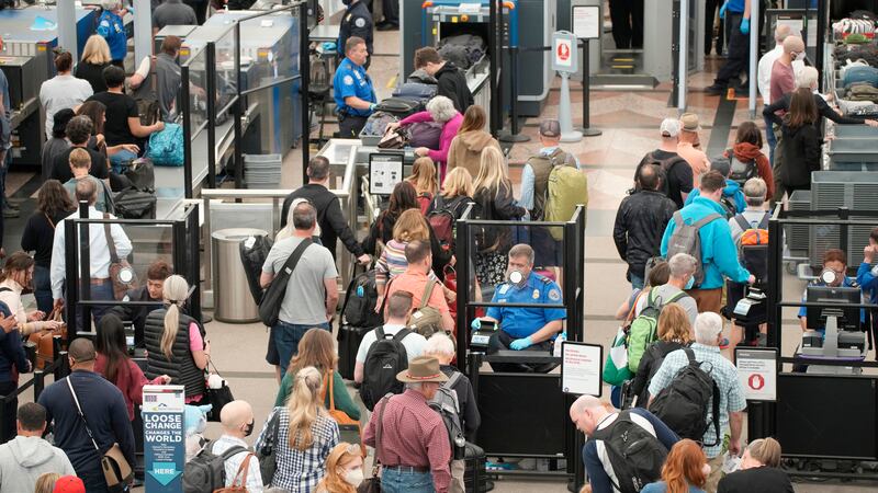 FILE - Travelers queue up move through the north security checkpoint in the main terminal of...